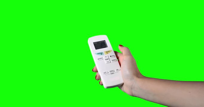 Woman hand holding a remote control and turning on the air conditioner, shot with green screen background, shot in 4k resolution