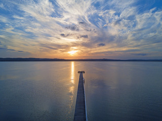 Aerial view of long jetty, Central Coast, Australia with cloudy sunset.