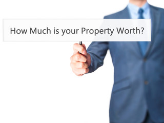How Much is your Property Worth? - Businessman hand holding sign