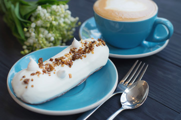 Coffee and eclair on the rustic background. Concept and idea