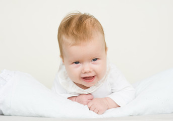 Smiling baby girl lying on her stomach