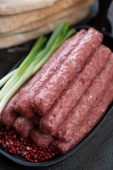 Close-up of fresh balkan skinless sausages or cevapi, selective focus, vertical shot
