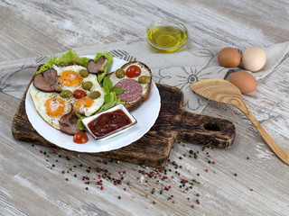 fried eggs with bacon, olives and tomatoes a hearty breakfast. 
