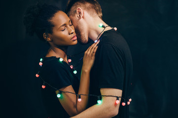 Young interracial couple, tenderness and love. Strong hug, man and woman bound together.