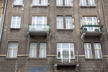 The gray facade of the house with three balconies