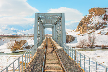 Railway bridge against white mountains