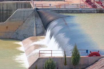 Foto auf Acrylglas Damm Wasser, das über den Rand eines kleinen Damms kaskadiert