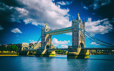 Tower Bridge in London, UK. The bridge is one of the most famous landmarks in Great Britain, England, Picture with sunlight and cloudy sky with high contrast.