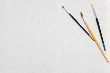 White canvas and painting brushes. Professional painter workplace flat lay. Artist's equipment...