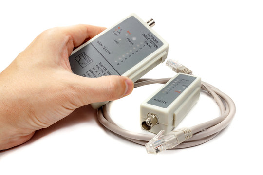 Network cable tester in man's hand and remote probe with UTP cable on a white background