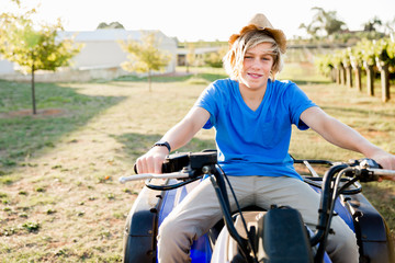 Obraz premium Boy riding farm truck in vineyard
