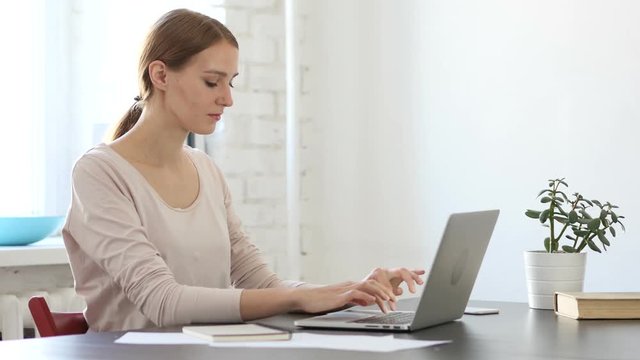 Young Creative Woman Working On Laptop in Office
