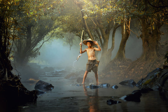 Boy fishing in river, Thailand
