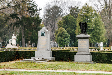 Obraz premium Old Vienna Austrian cemetery architecture with statues and marble tombstones for the graves