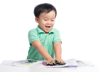 Portrait of cheerful asian boy playing with watercolors
