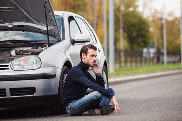 Man calling by phone to get help with his damaged car