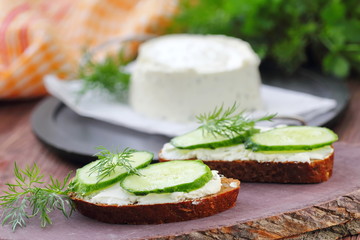 Sandwiches with soft cheese, cucumbers and greens