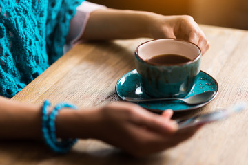 Cheerful girl messaging on smartphone during coffee break
