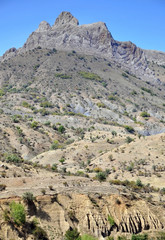 Fototapeta na wymiar Crimea Mountains. Mountain rocky ridge with peaks against the blue sky in the summer. Vertical view.