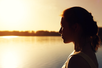 Young woman looking into the distance at sunset
