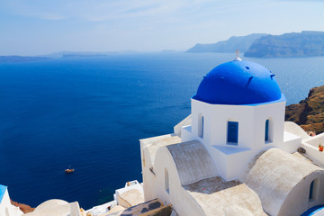 traditional blue dome of church and blue sea water, Oia, Santorini island, Greece