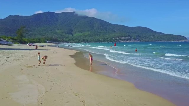 Camera Flies over Wonderful Ocean Beach with Happy Tourists