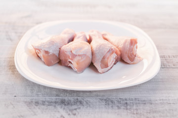 Chicken legs on a plate. On an ecological background. Raw chicken legs.