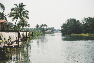 Fototapeta na wymiar Mandrem Beach resort, a lagoon with hotel gazebos against the backdrop of coconut palms.