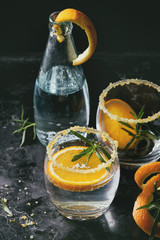 Tonic water cocktail with rosemary and orange. Two glasses and bottle with zest sugar and bubbles...