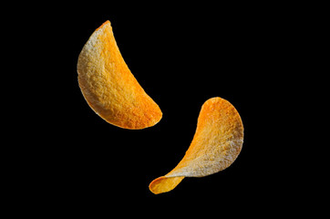 Falling potato chips isolated on black background