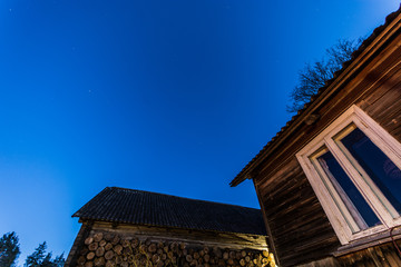 Overhead milky way with stars in clear summer night. Old barn house. Country side.
