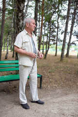 Old man staying near park bench.