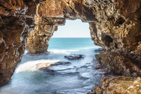 Long exposure image of caves of creek of Moraig, Benitatxell, Spain with mediterranean sea