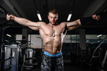 Fototapeta na wymiar Brutal strong athletic men pumping up muscles train in gym