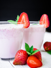 Blueberry smoothie with strawberry on rustic wooden background