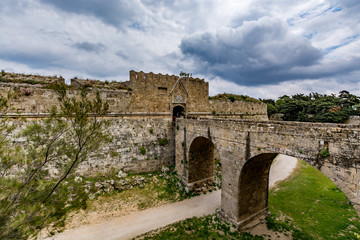 Fototapeta na wymiar Gate of Saint John, bridge leading to it and moat at Rhodes old town, Greece