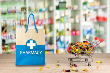 Recycled paper bag with a blue Pharmacy logo on a drugstore counter with pharmacy background shelf...