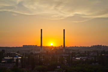 Sunset between two pipes of power plant at Voronezh industrial area
