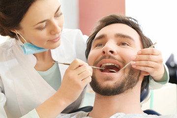 Obraz na płótnie Canvas Dentist examining patient's teeth in clinic