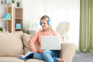 Young woman listening to audio book at home