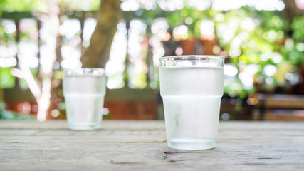 a glass of water on a wooden table.