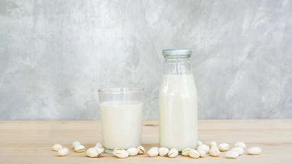 Pistachios milk on a wooden table.