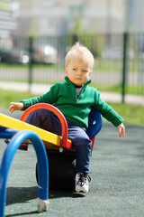 Fototapeta premium One year old baby boy toddler wearing green sweater at playground