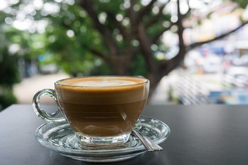Cappuccino art cup with black table, side view