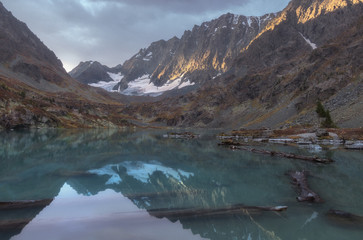Mountain lake on a background of autumn snow capped mountains