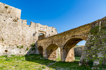 Fototapeta na wymiar Gate of Saint John, bridge leading to it and moat at Rhodes old town, Rhodes island, Greece