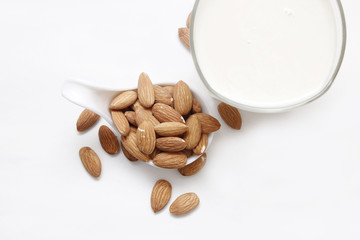 Almond milk in bottle with nuts isolated on white background