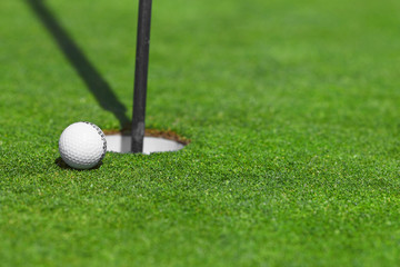 golf ball on lip of cup