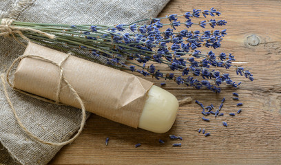Lavender soap with a bouquet of dried lavender on a wooden background