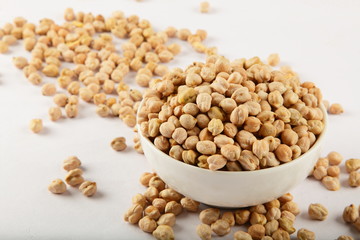Uncooked chickpeas in white bowl.